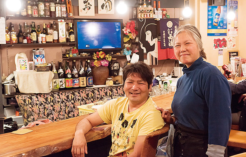 典子さんと共に笑顔を見せるのは、「みんな温かくて、ついつい来てしまう」という沖縄から単身赴任中の金富さん。この日福岡に戻ったばかりで、お土産を片手に来店していた。 店内